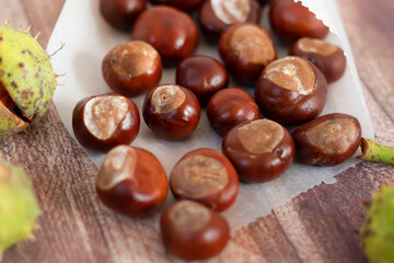 Chestnuts on a wooden table, in a paper bag