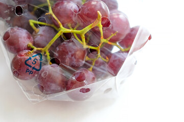 Large grapes in labeled packaging. On a light background