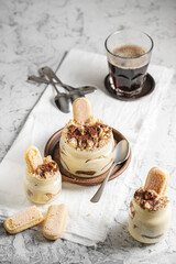 Tiramisu in jars with savoiardi cookies and cocoa powder