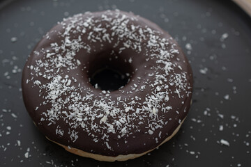 chocolate donuts on a black plate, pastries are sweet