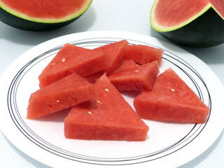 Juicy red watermelon slices on a white plate