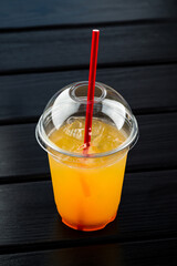 cold orange lemonade in a plastic cup to take away