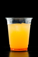 cold orange lemonade in a plastic cup to take away