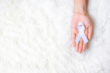 November Lung Cancer Awareness month, democracy and international peace day. Man holding white Ribbon on white background