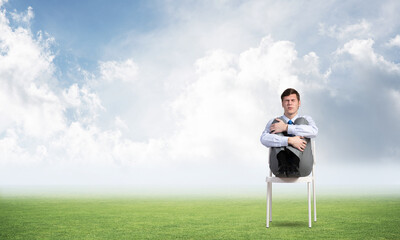 scared businessman on a chair