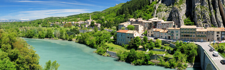 Fototapeta na wymiar View From The Fortress Of Sisteron To The Green Shimmering River Durance And Sisteron France On A Beautiful Summer Day With A Clear Blue Sky