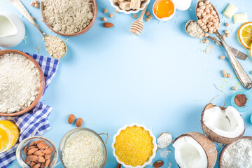 Cooking baking background frame background. Selection of various gluten free flour and ingredients, for sweet and bread bakery, on colorful blue kitchen table with utensils, eggs, sugar, cinnamon