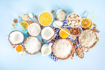 Cooking baking background frame background. Selection of various gluten free flour and ingredients, for sweet and bread bakery, on colorful blue kitchen table with utensils, eggs, sugar, cinnamon