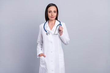 Photo of cute charming lady doctor wear white formal coat smiling walking isolated grey color background