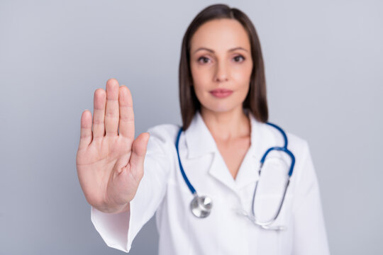 Photo of pretty confident woman doc dressed white coat rising palm asking stop isolated grey color background