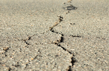Close-up of a deep crack in the road surface.