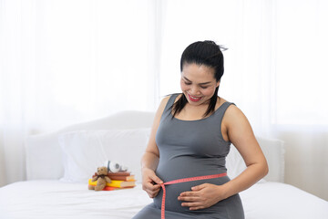 pregnant woman measuring tape her belly to check baby development. Healthcare and wellness. Health well being pregnancy lifestyle concept.