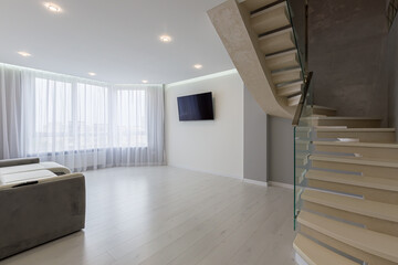 interior of a large living room with gray walls and stairs in a modern style