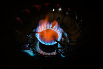 Blue flame gas stove in the dark. Selective focus with shallow depth of field.
