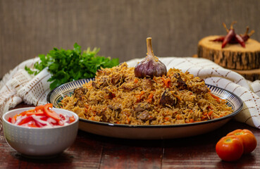 Delicious Fergana pilaf. Uzbek favorite dish on wooden background