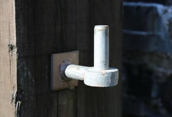 A closeup view of half an eye bolt hinge on a gate in Wales, UK.