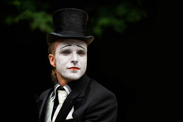 portrait of elegant expressive male mime artist posing on black background. Close-up portrait of a male mime artist. Halloween costume.