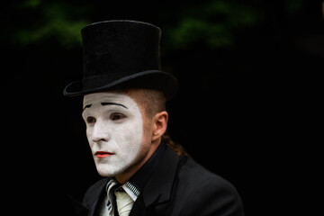 portrait of elegant expressive male mime artist posing on black background. Close-up portrait of a male mime artist. Halloween costume.