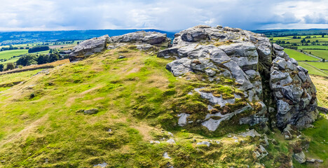 An aerial panorama view of the summit of Armscliffe Crag and the Lower Wharfe Valley in Yorkshire, UK in summertime