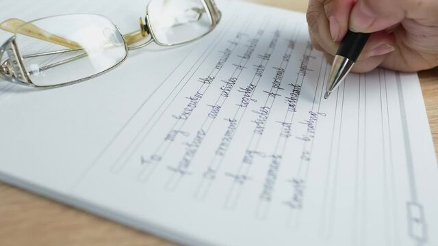 close-up female hand writes with a pen on paper the words of will, the concept of a legal order on her movable and immovable property in the event of a person's death for the heirs