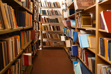 Collection of different books on shelves in library