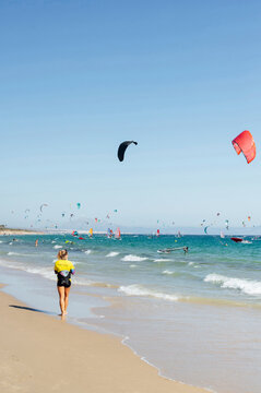 Female instructor walking at beach during sunny day