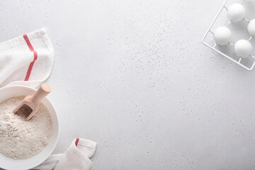 Baking background with flour, eggs, kitchen tools, utensils and cookie molds on white marble table. Top view. Flat lay style. Mock up.