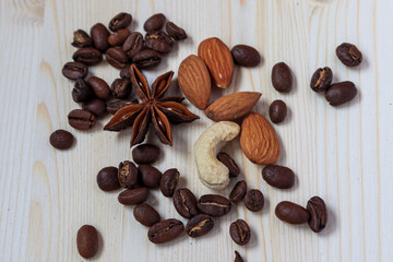 scattering of coffee beans, almonds, cashews, anise on a wooden background