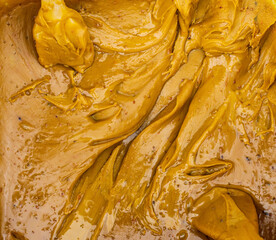 Yellow textured pasty mass of bee honey. Product for sale.