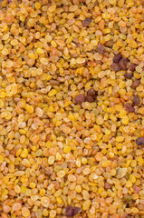 Light yellow raisins (dried grapes) lie on the counter and form an abstract texture.