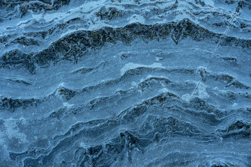 Natural rock texture of air and water eroded blue rock wall in a beach
