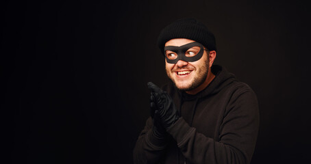 Portrait of funnu thief with mask over dark back