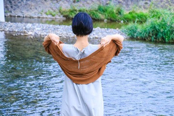 ショートへアの女性モデルと川
