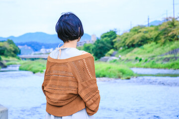川岸から遠くを眺める女性　ショートヘアの女の子