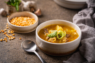 Closeup of a bowl of split pea soup with chunks of ham and meat
