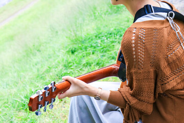 緑の房原でアコースティックギターを弾く女性