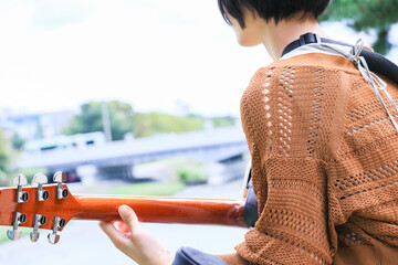 アコースティックギターを弾くショートヘアの女の子