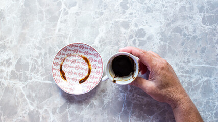 Woman hand holding Turkish coffee cup for fortune telling.
