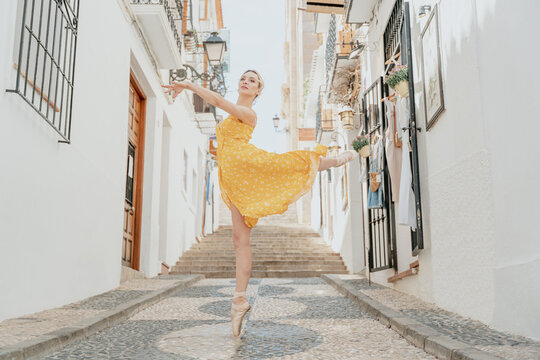 Graceful ballerina standing on tiptoe and raising leg