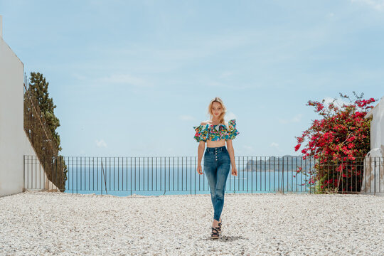 Stylish woman standing on roof of coastal house