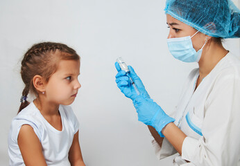 Female doctor injecting vaccine to girl