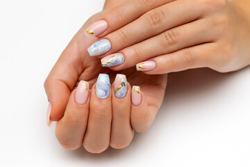 Bolero nail shape. Nude, natural manicure with blue, white veins and gold foil on long nails. Gel nails. Heavenly manicure. Close-up on a white background. - obrazy, fototapety, plakaty