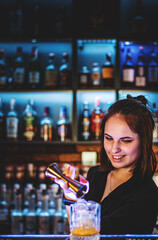 Portrait of young attractive woman bartender Making Cocktail in bar