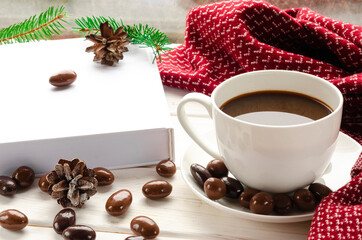 Winter background - cup with candy cane, woolen scarf on windowsill and winter scene outdoors