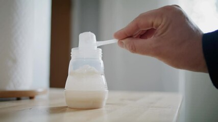 Man Father Prepares Baby Formula with Bottle In Clean Kitchen for Toddler Infant
