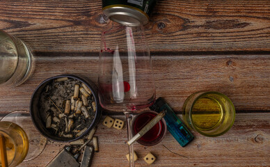 Wooden brown table with alcohol bottles and glasses and marijuana ashtray