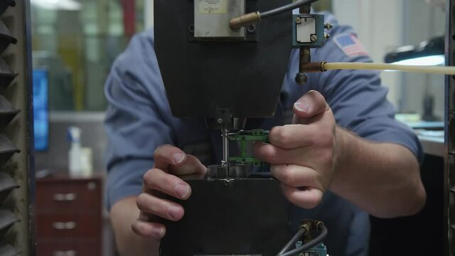 American USA Engineer with Flag Patch Uses Machine to Test Durability of Metal