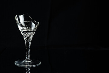 Broken crystal wine glass isolated on black background.