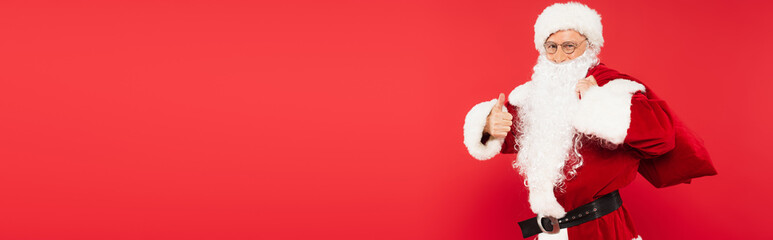 Santa claus holding sack and showing like isolated on red, banner