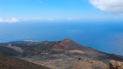 Volcanic landscape with the Teneguia volcano on La Palma. Rough landscape without trees. Rocks and lava. Sea in the background. Summer picture in a warm environment. Landscape photography